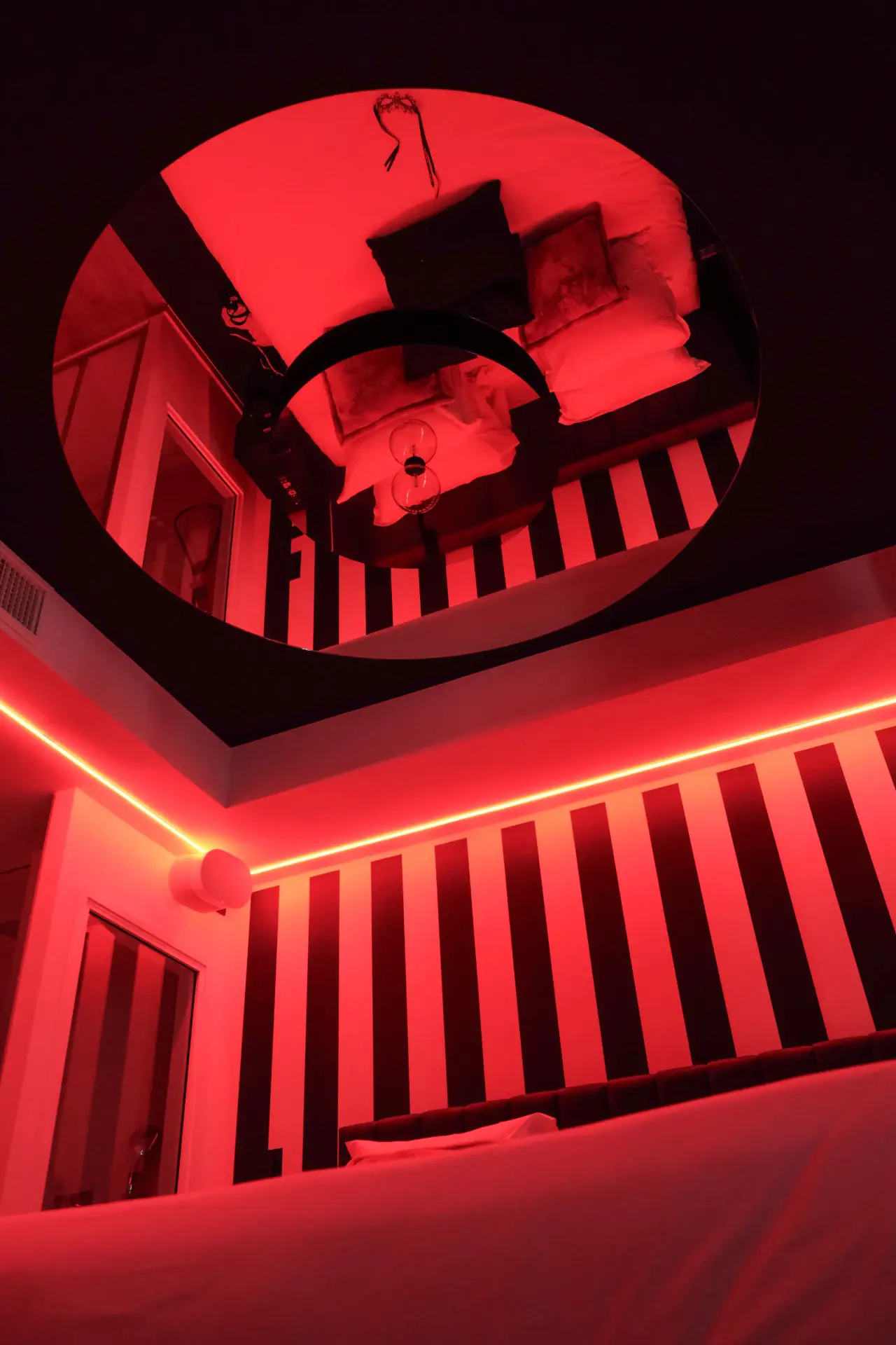 Miroir de plafond & LED rouge au-dessus du lit